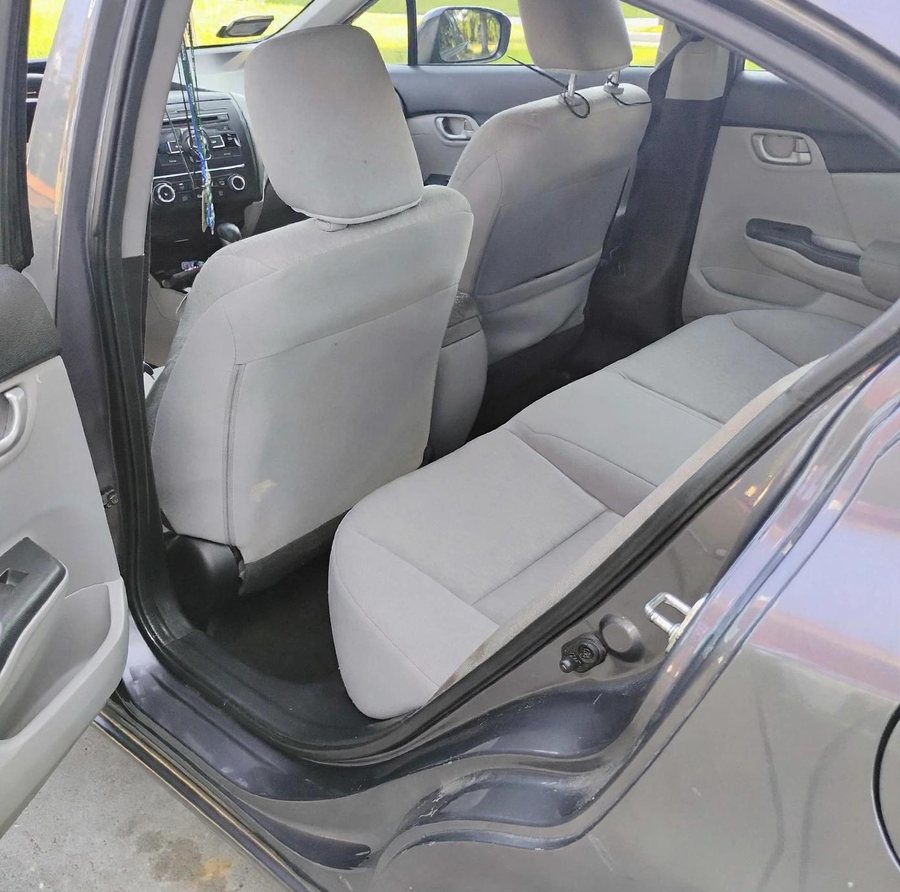 The back seat of the 2014 Honda Civic LX, cloth seats, door open